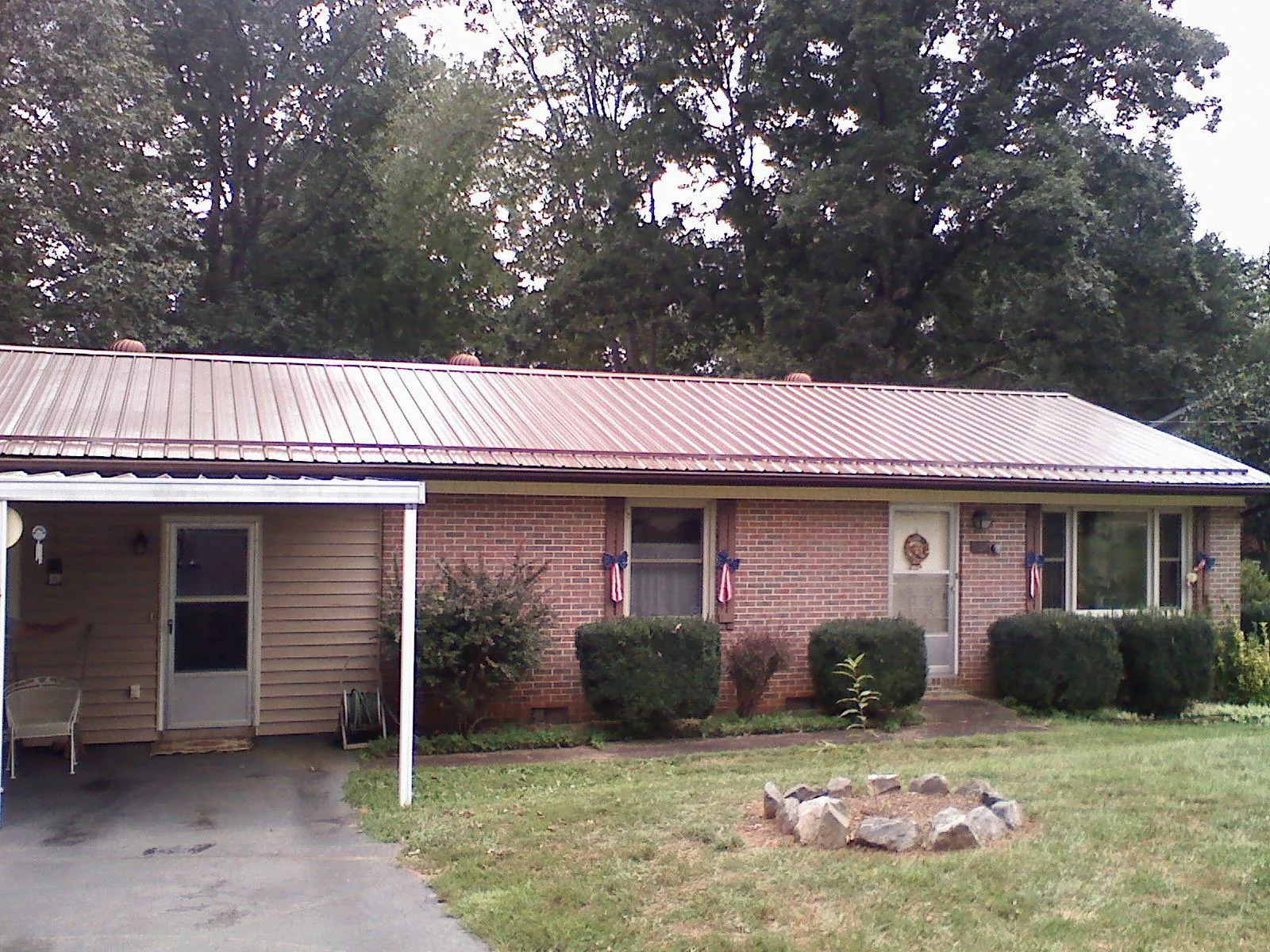 Bronze metal roof and carport on a brick ranch home — Roof Repair work by our crew in Archie